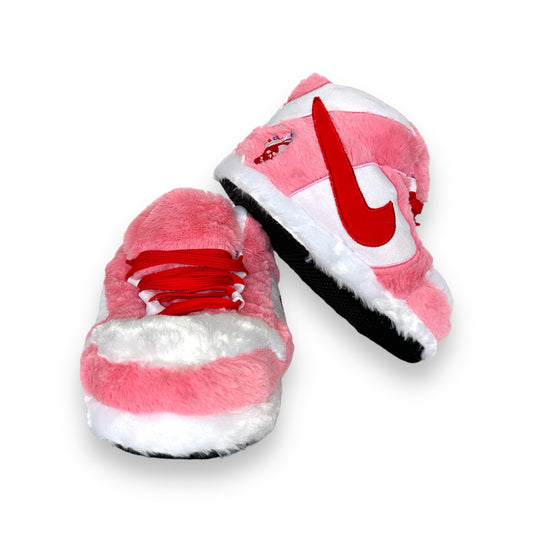 Top view of OG Pink Sneaker Slippers showing pink and white plush material, lace details, and red side design.