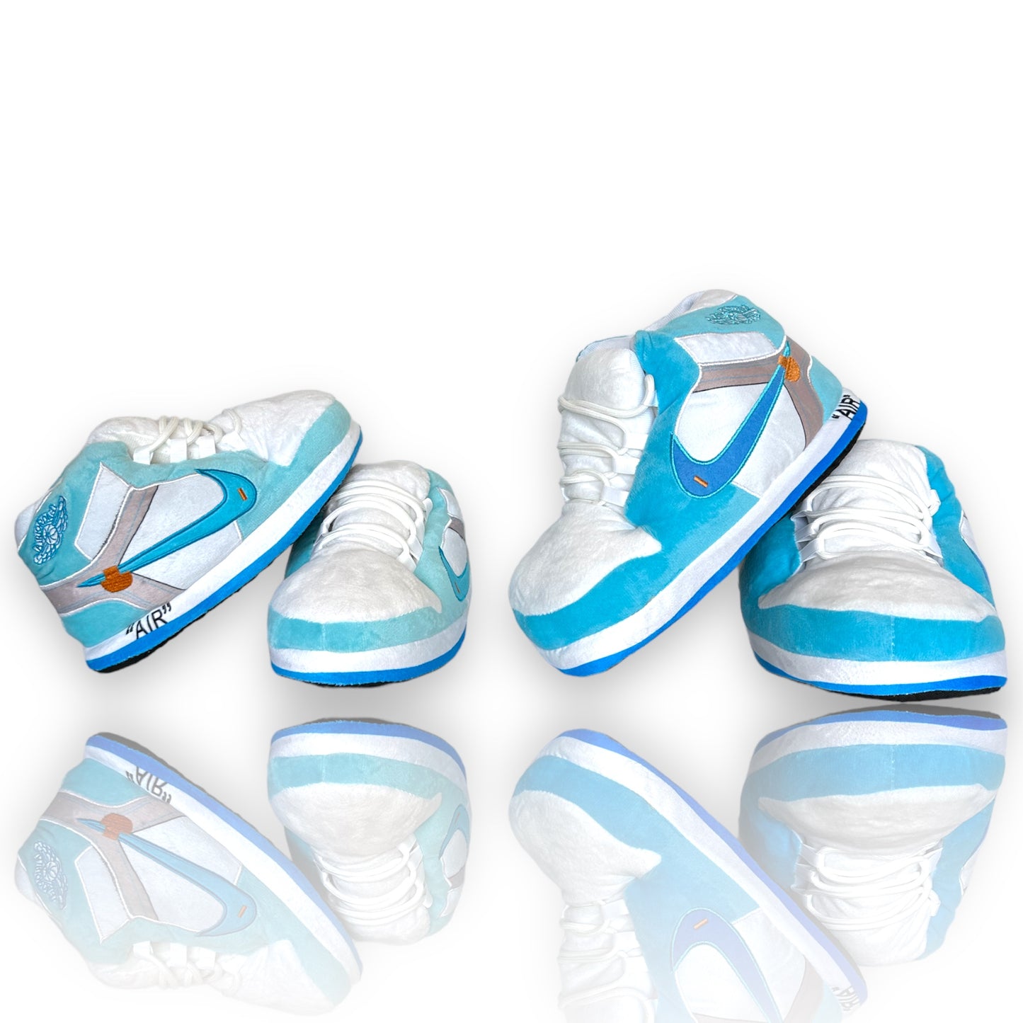 OG AIR Sneaker Slippers – baby-blue and white plush sneaker-style slippers for adults and adultswith grey accents and foam soles on white background and reflective bottom.